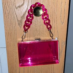 A clear pink purse, and a black glam mini hand bag